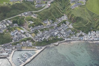 Oblique aerial view of Gardenstown and harbour, looking to the SE.