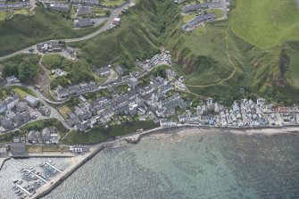 Oblique aerial view of Gardenstown and harbour, looking to the SE.