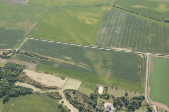 Oblique aerial view of the cropmarks of the settlements, unenclosed houses and pit alignment at Congalton, looking S.