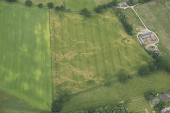 Oblique aerial view of the cropmarks of the pits and possible round house at Moniack Castle, looking NNW.