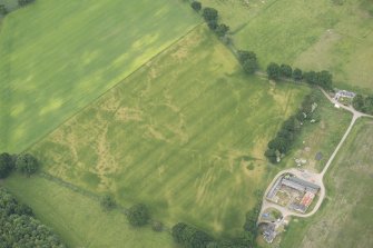 Oblique aerial view of the cropmarks of the pits and possible round house at Moniack Castle, looking WNW.