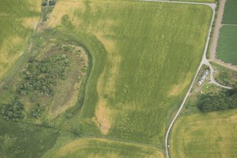 Oblique aerial view of the cropmarks of the enclosure, possible round house and pits, looking NE.