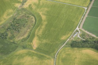 Oblique aerial view of the cropmarks of the enclosure, possible round house and pits, looking NNE.