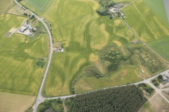 Oblique aerial view of the cropmarks of the fort, linear feature, enclosure, and pits at Gilchrist, looking SE.