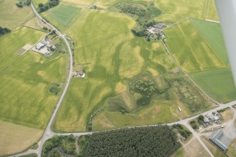 Oblique aerial view of the cropmark fort, linear feature, enclosure, and pits at Gilchrist, looking SE.