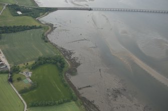 Oblique aerial view of the fish traps, pier and enclosures in the Cromarty Firth, looking WSW.