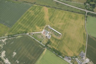 Oblique aerial view of the cropmarks of the enclosure and possible unenclosed settlement, looking WNW.