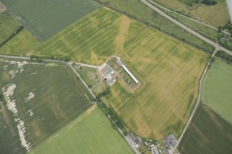 Oblique aerial view of the cropmarks of the enclosure and possible unenclosed settlement, looking W.