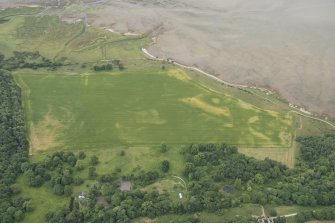 Oblique aerial view of fish traps and the cropmarks of the enclosures at Tarbat House, looking S.