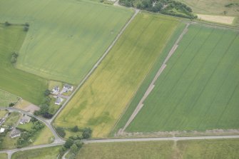 Oblique aerial view of the cropmarks of the vallum at Portmahomack, looking SE.