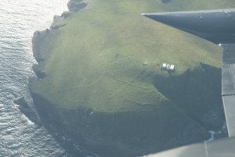 Oblique aerial view of Tobha Ronaigh, centred on North Rona lighthouse, looking to the W.