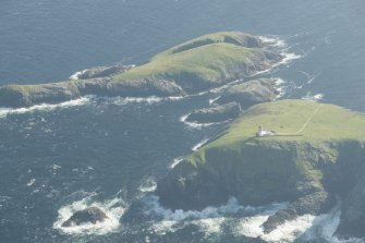 Oblique aerial view of the Flannan Isles, with the lighthouse on Eilean Mor in the foreground and Eilean Tighe beyond, looking to the SSW.
