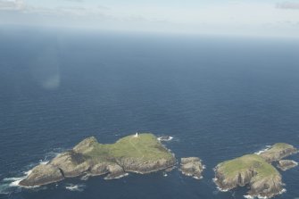 General oblique aerial view of the Flannan Isles, with the lighthouse on Eilean Mor to the left and Eilean Tighe to the right, looking to the NE.