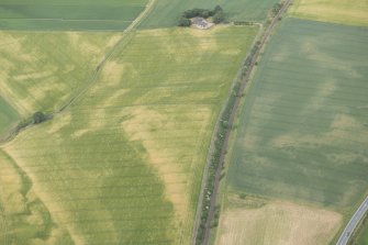 Oblique aerial view of the cropmarks of the palisaded enclosures and round house, looking NE.