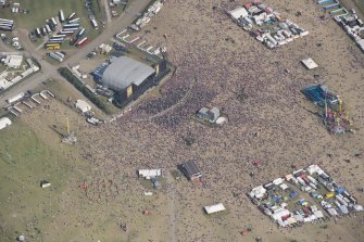 Oblique aerial view of the T in the Park festival at Balado, looking  E.