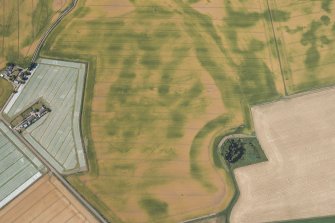 Oblique aerial view of the cropmarks of the unenclosed and palisaded settlements, enclosures and pits, looking WSW.