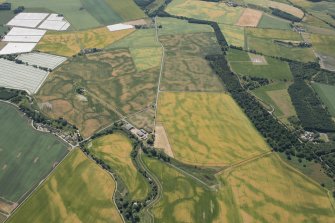 General oblique aerial view centred on the cropmarks of the enclosures, timber hall and unenclosed settlement, looking SSE.