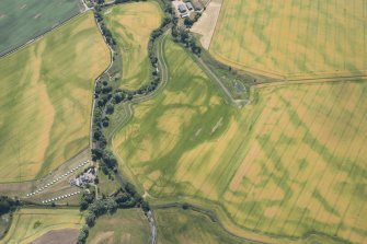 Oblique aerial view centred on the cropmarks of the unenclosed settlement, barrows, linear features and pits, looking SE.