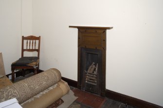 Interior, first floor, detail of fireplace in servants' bedroom.