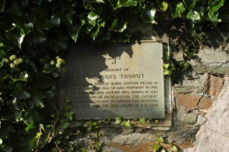 Detail of 'Francois Thurot' memorial plaque adjacent to church doorway.