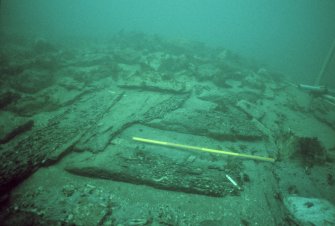 Starboard framing and partly eroded ceiling planking as they emerge from the forward ballast-mound. Scale 1 metre. (Colin Martin)