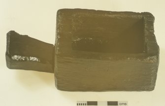 A wooden box with integral handle. This can be identified as an ‘oil box’, used to hold linseed oil as a sealant when calking the joints of the outer hull planks with oakum (teased-out hemp fibre). Scale in centimetres. (Colin Martin)
