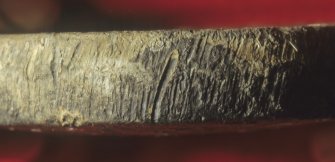 Detail of the edge of the 4-pound lead balance-pan weight (DP97/A021) showing file-marks, presumably cut to bring the weight to the correct value. The actual weight was almost exactly 4 pounds avoirdupois. (Colin Martin)