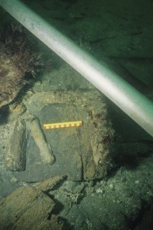 Rear underside view of the inverted gun-carriage (DP00/013) associated with Gun 8 (DP00/203), showing the remnants of the two rear chocks. The concretions are not associated with the carriage. Scale 15 centimetres. (Colin Martin)