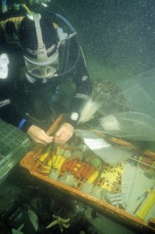 An archaeologist detaches a finds identifying label to be bagged with its nominated find. (Colin Martin)