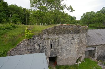 Kiln B from the top of Kiln A. The levelled causeway from the quarry is seen running to the top of Kiln B from centre left. The SE draw-arch is at the lower right, while the doorway into the room behind the kilns is towards the left, beneath two ventilation slots. Support slots and masonry fill above them indicate the probable abutment of a demolished bridge, once linking Kilns A and B. The upper levels of Kiln B suggest a later heightening of the structure. Scale 2 metres. (Colin Martin)