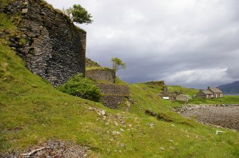 Sheep Island (Eilean nan Caorach). View along the kiln frontages, looking NE. The lime-workers’ bothy, now a holiday home, is on the right. Above it, on the skyline, is Kiln 1. Between the bothy and Kiln 1 is a complex of stores and workshops. Kiln 2 is left of centre, with a tree growing out of its top. Kiln 3, with its extension, is at the upper left. (Colin Martin)