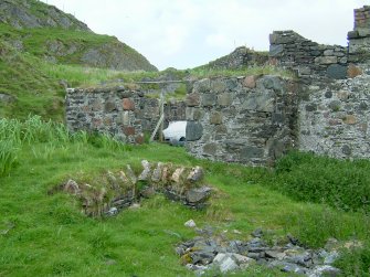 Remains of one of two wells on the island. Behind is the wide entrance to the unroofed enclosure which was probably a coal store. (Paula Martin)