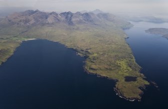 Aerial photograph of the Rubh’ an Dùnain peninsula from the W, with the Cuillin Hills rising in the background. Loch na h-Airde is close to the tip of the peninsula. Loch Brittle is on the left, with Glenbrittle at its head. (Edward Martin)