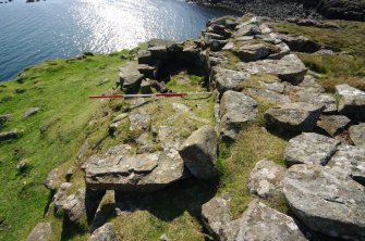 Headland fort, detail of chamber and external wall (on right) showing evidence of re-build. Scale 2 metres. (Colin Martin)