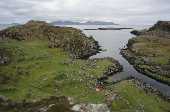Headland fort (skylined, on left), the two nausts below it, and the canal leading into Loch na h-Airde. The islet of Sgeir Mhòr and the sheltered anchorage lie beyond. Rum is on the horizon, and the headland on the far left is Dùnan Thalasgair on Eigg, which according to tradition was a watch-post and signal-stance linked to Rubh’ an Dùnain. (Colin Martin)