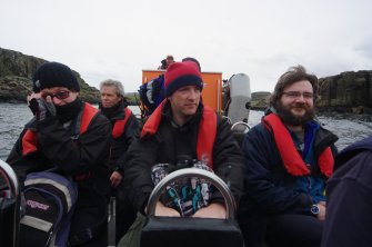 Fast, comfortable access is available – at a price – by rigid inflatable boat from Elgol. This occasion, in 2012, was underwritten by the BBC, who were making a programme. At centre is Dr Jon Henderson (University of Nottingham) who was presenting the programme and providing expertise on the archaeology of the site. On the right is Edward Martin, who has been developing drone photography and photographic rectification for the project. (Colin Martin)