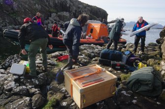 Filming, archaeological, and aerial drone equipment come ashore at Rubh’ an Dùnain. The drone system is in the box, centre foreground. (Colin Martin)