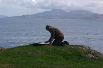 The site was potentially dangerous, and risk assessments were rigorous. Project Director Dr Colin Martin is more secure than he looks as he records details of the headland fort. (Paula Martin)