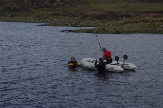 Trials have been made using sector scanning to search the loch bed for archaeological features. The equipment is seen here being positioned. Results so far have been encouraging, but a more sustained programme is required. (Colin Martin)
