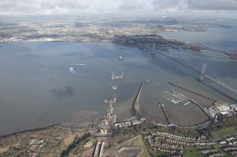 General oblique aerial view of the construction of the new Queensferry, the Forth Road Bridge and Port Edgar, looking N.