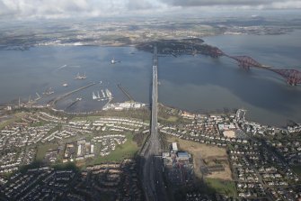 General oblique aerial view of the construction of the new Queensferry, the Forth Road Bridge and Port Edgar, looking N.