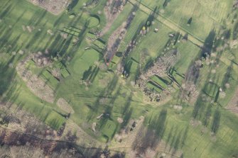 Oblique aerial view centred on part of the disused race course, the farmstead and the golf course, looking NNE.