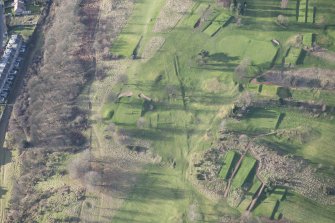 Oblique aerial view centred on part of the disused race course, the farmstead and the golf course, looking W.