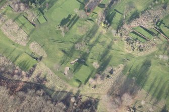 Oblique aerial view centred on part of the disused race course, the farmstead and the golf course, looking NNW.