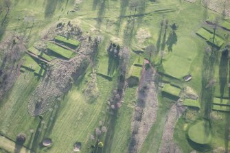 Oblique aerial view centred on part of the disused race course, the farmstead and the golf course, looking S.