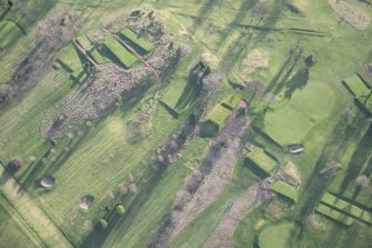 Oblique aerial view centred on part of the disused race course, the farmstead and the golf course, looking SSW.