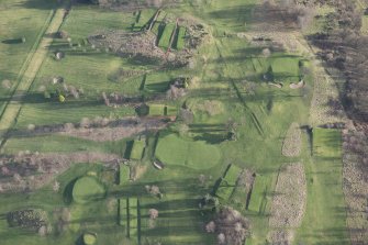 Oblique aerial view centred on part of the disused race course, the farmstead and the golf course, looking SE.