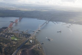 Oblique aerial view of the construction of the Queensferry Crossing, the Forth Road Bridge and Forth Rail Bridge, looking SSE.