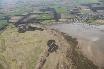 General oblique aerial view of remains of anti-tank blocks, Luffness new golf course and footbridge, looking SSE.