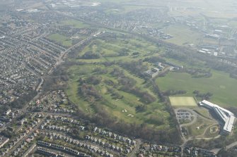 Oblique aerial view of Duddingston House and golf course and Holyrood Roman Catholic Secondary School, looking to the SE.